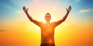 Confident person in vibrant colors against a sunrise backdrop.